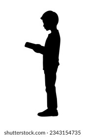 Silhouette of a boy reading a book while standing