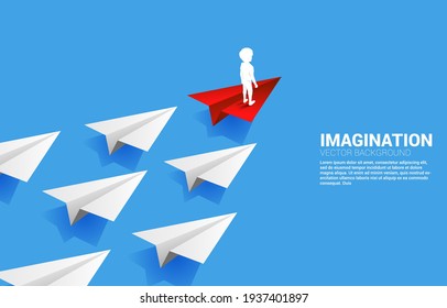 Silhouette of boy standing on red origami paper airplane leading group of white. Concept of children imagination and education.