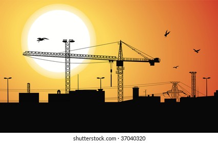 Silueta de un edificio que se construye con una grúa en la planta de construcción al atardecer.