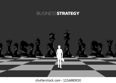 Silhouette of businessman with briefcase standing in front of chess piece. concept of business strategy marketing.