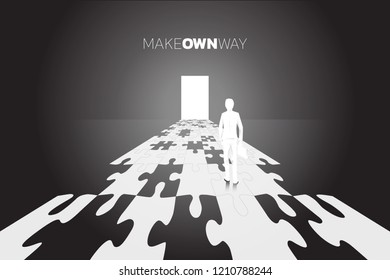 Silhouette of businessman with briefcase standing on road to the door from jigsaw piece. business concept of make you own way. 