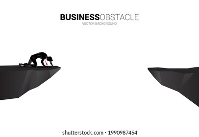 silhouette of businessman  crawling  on the cliff. Concept for dead end business and obstacle.