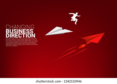 silhouette of businessman jump from white origami paper airplane to red for change direction. Business Concept of changing business direction.Company vision mission.