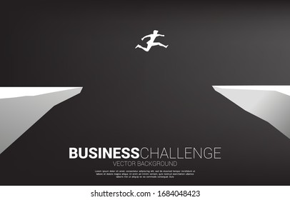 silhouette of businessman  jumping over the gap of valley. concept of business challenge risk.