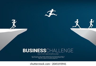 silhouette of businessman  jumping over the gap of valley with city background. concept of business challenge risk.