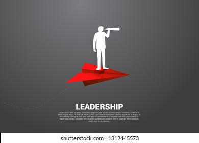 Silhouette Of Businessman Looking Through Telescope On Red Origami Paper Airplane. Business Concept Of Leadership And Vision Mission.