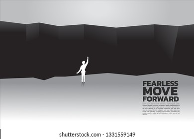 silhouette of businessman planning to cross abyss. concept of business challenge and courage man