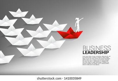 silhouette of businessman point forward on red origami paper ship leading group of ship. Business Concept of leadership and vision mission.