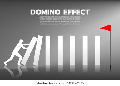 Silhouette of businessman pushing the block to create domino effect to hit the goal. business concept of try to make the domino effect