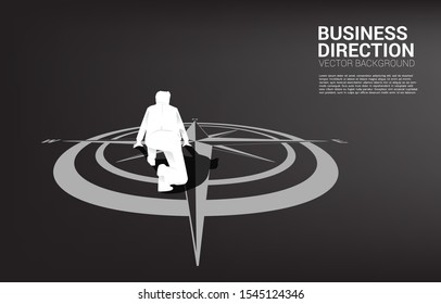 Silhouette of businessman ready to run from center of compass on floor.Concept of career path and business direction