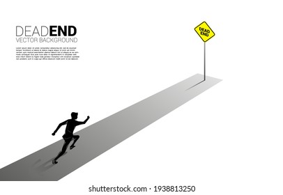 Silhouette businessman running to the end of road with dead end signage . Concept of wrong decision in business or end of career path.