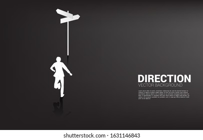 Silhouette of businessman standing at direction signage. Concept of time to make decision in business direction