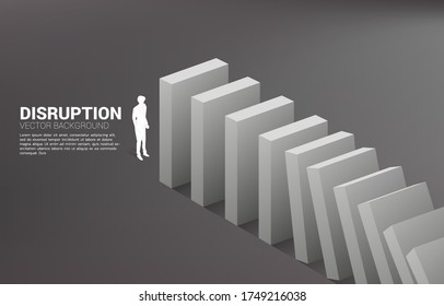 Silhouette of businessman standing at the end of domino collapse. Concept of business industry disrupt