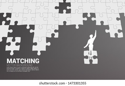 Silhouette of businessman standing on final jigsaw piece. Concept of perfect recruitment. Human Resource. put the right man on the right job.