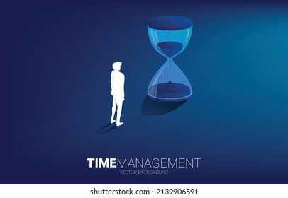 Silhouette of businessman standing with sand clock. The concept for office employee and working time.