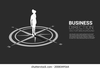 Silhouette of businesswoman standing at center of compass on floor.Concept of career path and business direction