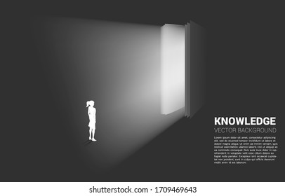 Silhouette of businesswoman standing in light from open book. Concept of knowledge of book