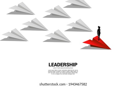 Silhouette of businesswoman standing on red origami paper airplane leading group of white. Business Concept of leadership and vision mission.