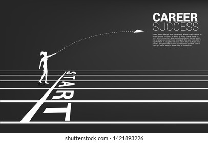 silhouette of businesswoman throw out origami paper airplane from start line on running track. Business Concept of start business and entrepreneur