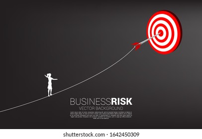 silhouette of businesswoman walk rope to arrow archery hit on the center of target. Concept of targeting and Business challenge.