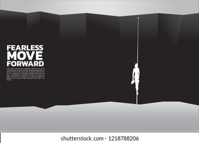 silhouette of businesswomen with briefcase walking on the rope to cross abyss. concept of business risk, challenge and courage women