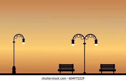 Silhouette of chair and street lamp on garden