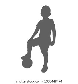 Silhouette of a child and the ball, standing foot on the ball. The boy plays football.