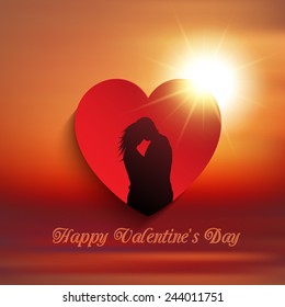Silhouette of a couple kissing in a heart against a sunset sky
