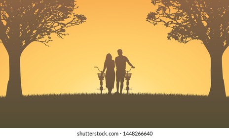 Silhouette couple man and woman walking together with bicycle under trees with sunset sky background