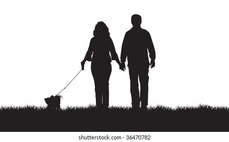 silhouette of a couple walking their dog