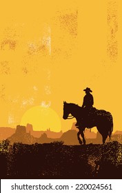 Silhouette of cowboy riding horse at sunset