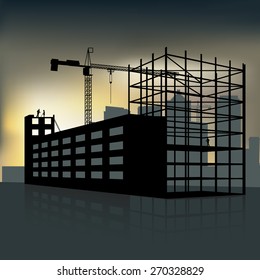 silhouette of the crane and building under construction at sunset
