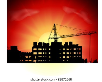 Silhouette of crane on a sunset on a building