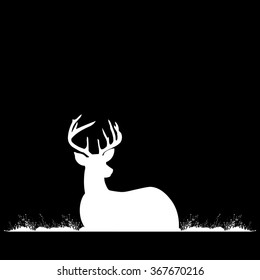 Silhouette of deer with antlers on the grass.