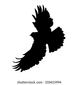 A silhouette of an eagle or hawk in mid flight