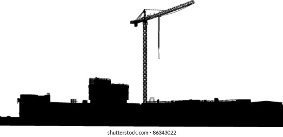 Silhouette of the elevating crane against building