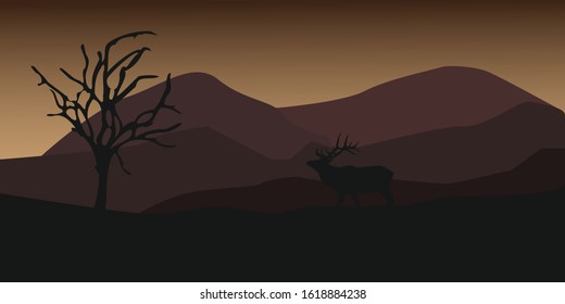 Silhouette of an elk at night with mountains in the background