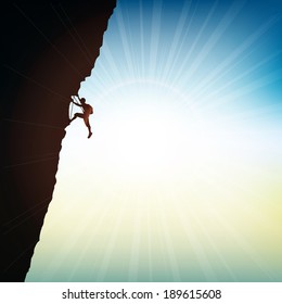 Silhouette of an extreme rock climber against a sunny sky