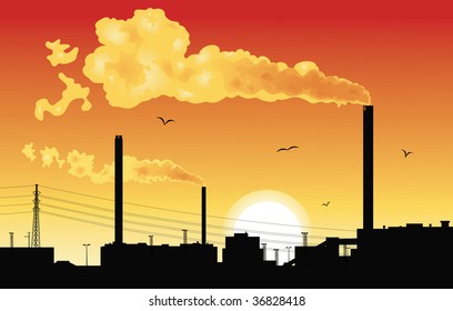 Silhouette of a factory with smoke coming out of chimneys at sunset.