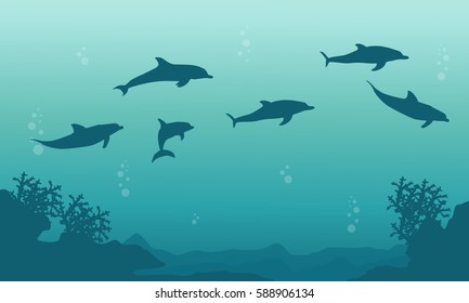 Silhouette of family dophin on sea landscape