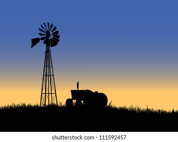 Silhouette of a farm tractor and windmill.