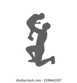 Silhouette father and child. A man stands on one knee and raises the boy in his arms.