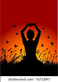 Silhouette of a female in a yoga pose against a sunset sky
