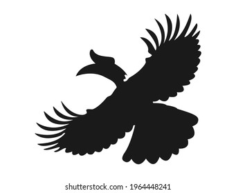 Silhouette of a flying hornbill with its wide wings opening