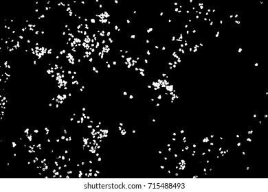 Silhouette of food flakes such as salt or almond or wheat flour spread on the flat surface or table. Abstract grainy texture isolated on black background. Top view of dust, sand blow or bread crumbs. 