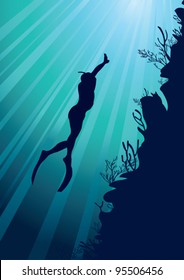 Silhouette of free diver and marine reef on a sun ray in sea