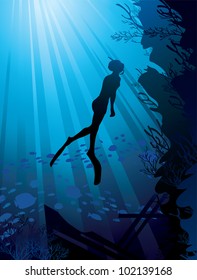 Silhouette of free-diver and marine reef on a sun ray in sea