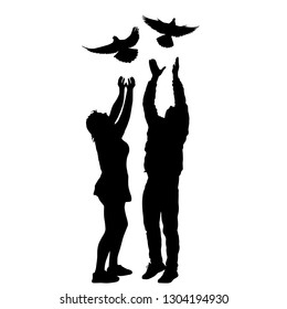 Silhouette of a guy and a girl letting go of the dove into the sky