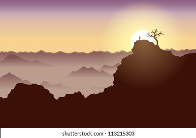 Silhouette of a guy standing on top of a high cliff.
