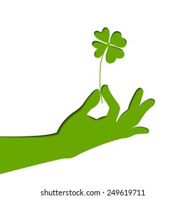 Silhouette of hand, holding four-leaf clover. Green paper illustration. Vector art on Patrick's day.